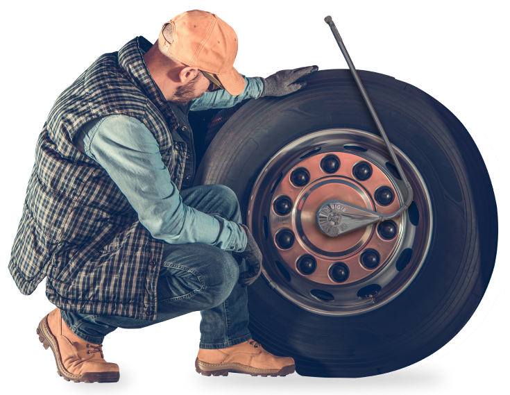 trabajador analizando la rueda de un camión